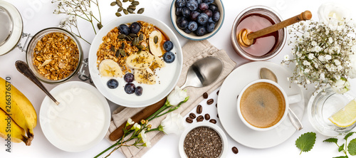 Bild auf Leinwand Oat granola with yogurt, honey, fresh bananas, blueberries, chia seeds in bowl