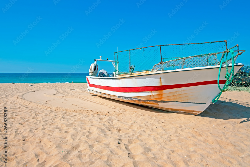 Old fishers boat on the beach in Armacao de Pera in the Algarve Portugal Old fishers boat on the beach in Armacao de Pera in the Algarve Portugal