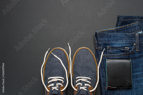 Mens summer casual clothes flat lay. Jeans, shoes and wallet. Mens summer casual clothing outfits and accessories flat lay on dark background, top view, fashion concept, copy space for text © Marina Dobryakova