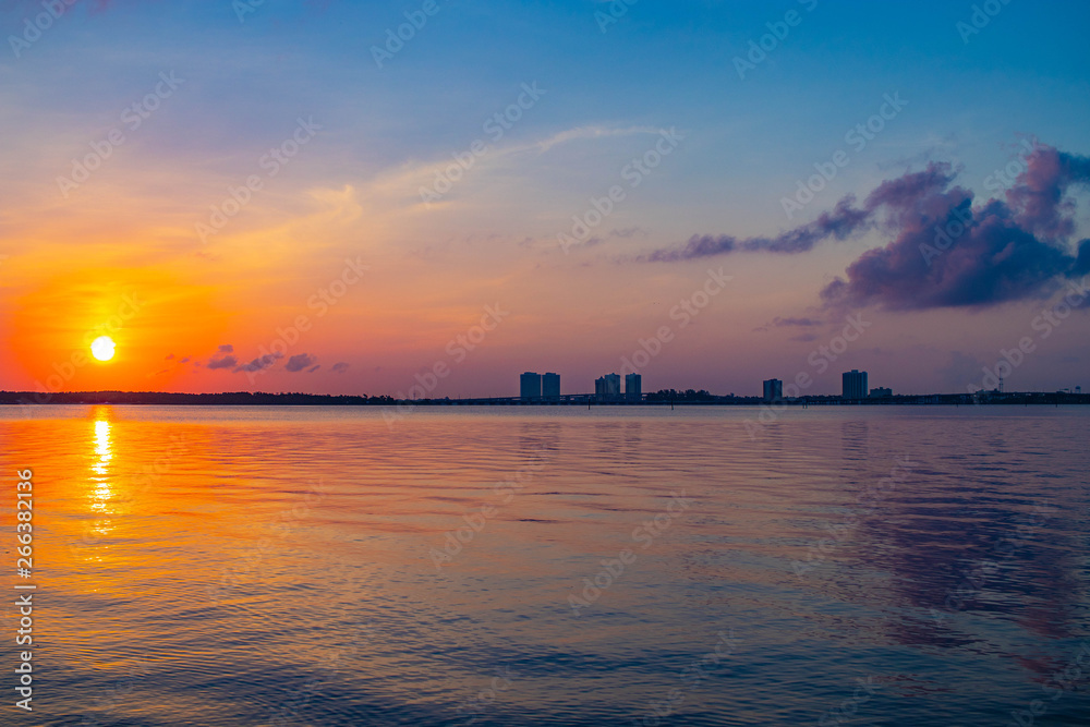 Naklejka premium Beautiful sun over the city of Fort Myers skyline reflecting of the gulf of Mexico 