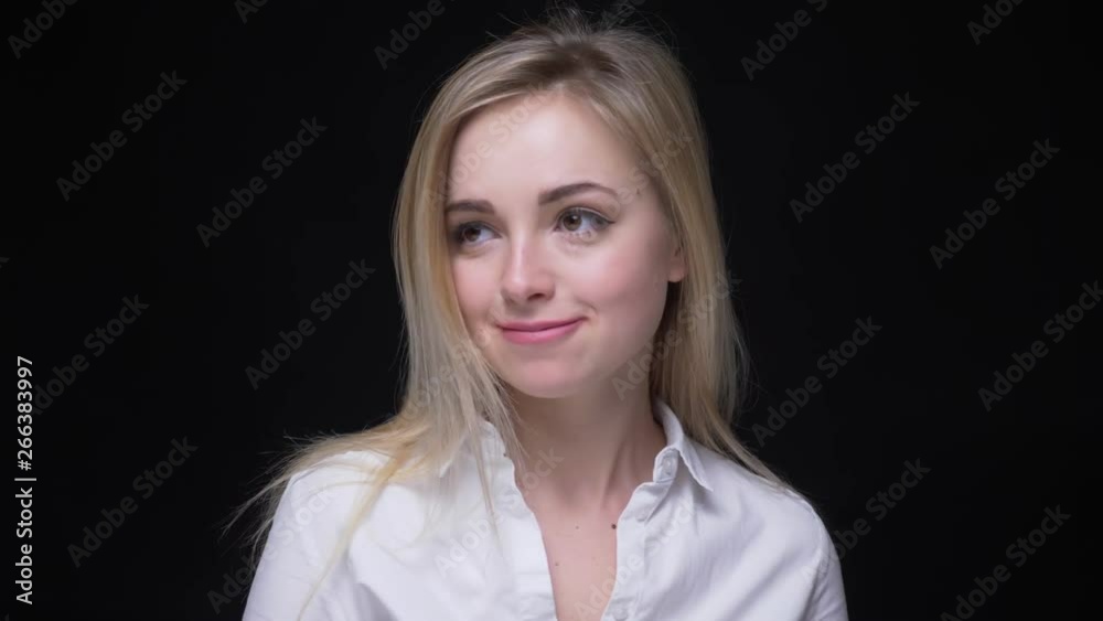 Pretty businesswoman in white shirt dancing slowly and shyly watching modestly into camera on black background. Pretty businesswoman in white shirt dancing slowly and shyly watching modestly into camera on black background.