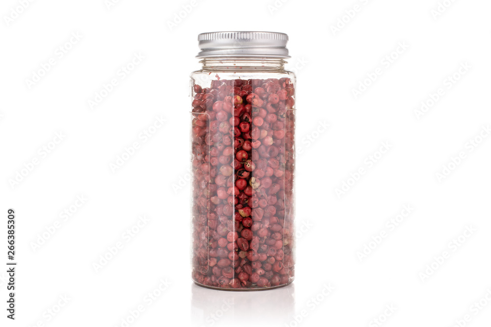 Lot of whole peruvian pink pepper in a plastic bottle isolated on white background Lot of whole peruvian pink pepper in a plastic bottle isolated on white background