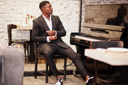 Photography Strong powerful african american man in black suit sitting against piano