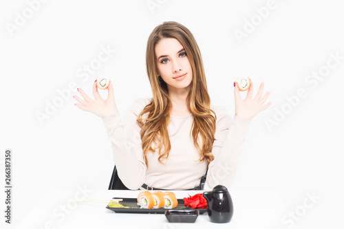 What can be better than sushi! Blonde midel holding two roll sushi on hand! photo