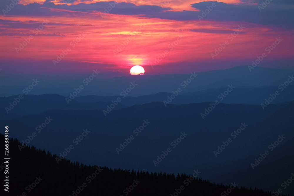 Fantastic sunset enlightens the sky with marvelous colors : bright pink, yellow, orange. The landscape of the mountains silhouette on the twilight. Unusual clouds. Location the Carpathian mountains. Fantastic sunset enlightens the sky with marvelous colors : bright pink, yellow, orange. The landscape of the mountains silhouette on the twilight. Unusual clouds. Location the Carpathian mountains.