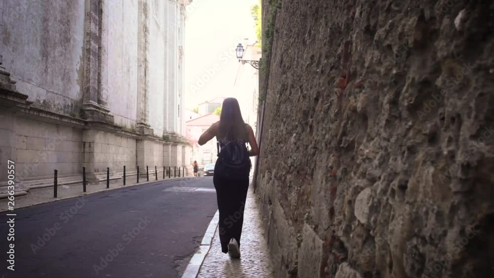 woman walking near an old wall woman walking near an old wall