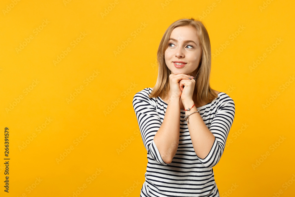 Portrait of cute young woman in striped clothes looking aside, put hand prop up on chin isolated on yellow orange background in studio. People sincere emotions, lifestyle concept. Mock up copy space. Portrait of cute young woman in striped clothes looking aside, put hand prop up on chin isolated on yellow orange background in studio. People sincere emotions, lifestyle concept. Mock up copy space.