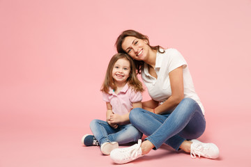 Woman in light clothes have fun with cute child baby girl. Mother, little kid daughter isolated on pastel pink wall background, studio portrait. Mother's Day, love family, parenthood childhood concept