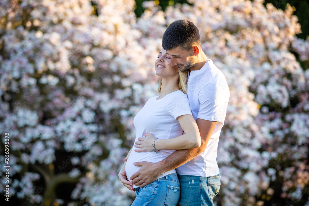 Happy couple expecting baby, pregnant woman with husband, young family and new life concept Happy couple expecting baby, pregnant woman with husband, young family and new life concept