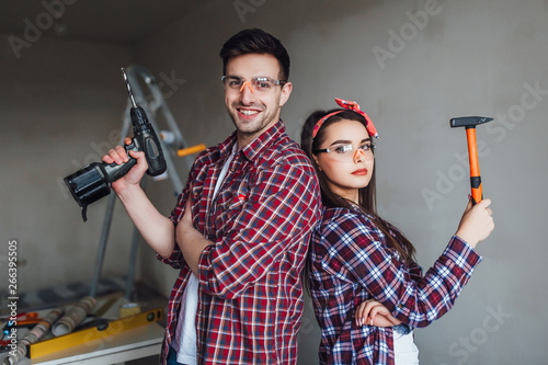 Obraz na plátně Beautiful couple doing repair at home , wearing protective clothes being well eq