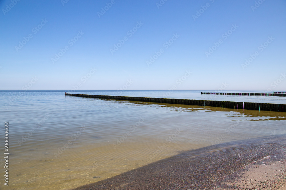 Groynes in the Baltic Sea with small waves in the seaside resort of Zempin on the island of Usedom