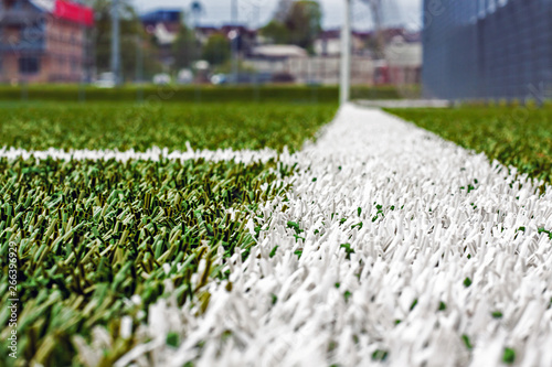 Close-up of a white line on a green artificial grass. Sport concept.