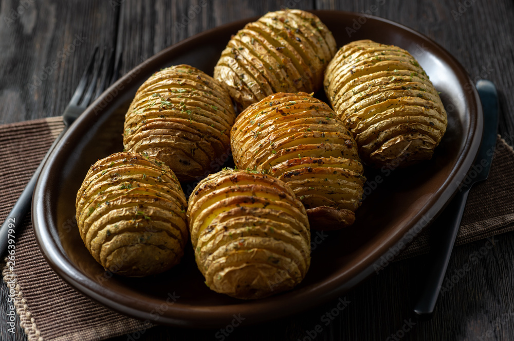 Hasselback potatoes baked with garlic and herbs in oven. Hasselback potatoes baked with garlic and herbs in oven.