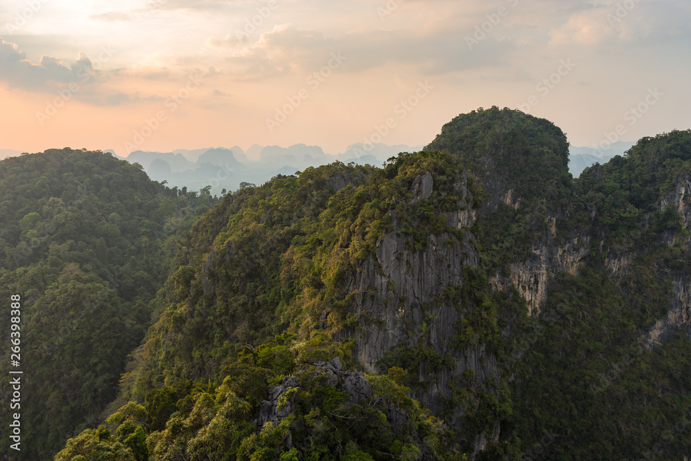 Mountain and cliffs in Thailand is covered with tropical greenery at sunset