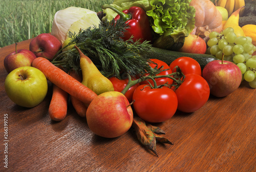 Various fresh vegetables and fruits on a wooden oak table