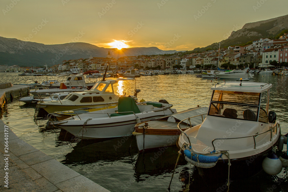 Boats parking in harbour in croatia in sunset. Landscape at sunset Small town of Baska . Island Krk. Adriatic coast, Croatia, Europe. Summer vacation. Relaxation Concept. Beaches of Croatia.