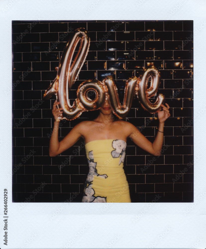 Young Asian woman portrait holding metallic love message balloon alone for valentine's day