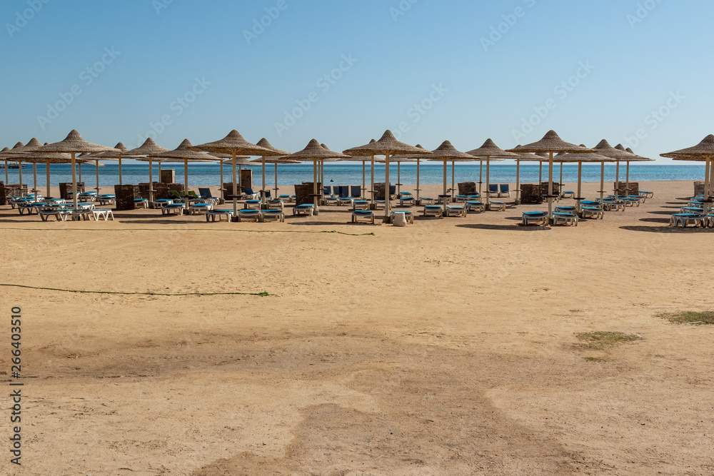 background of a deserted , abandoned beach with sunbeds, umbrellas overlooking the sea