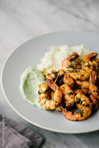Close up a plate of spicy shrimp with avocado aioli and mashed yucca