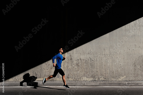 Handsome asian man running in the city. photo