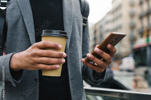 Closeup of a businessman in the city using his phone.