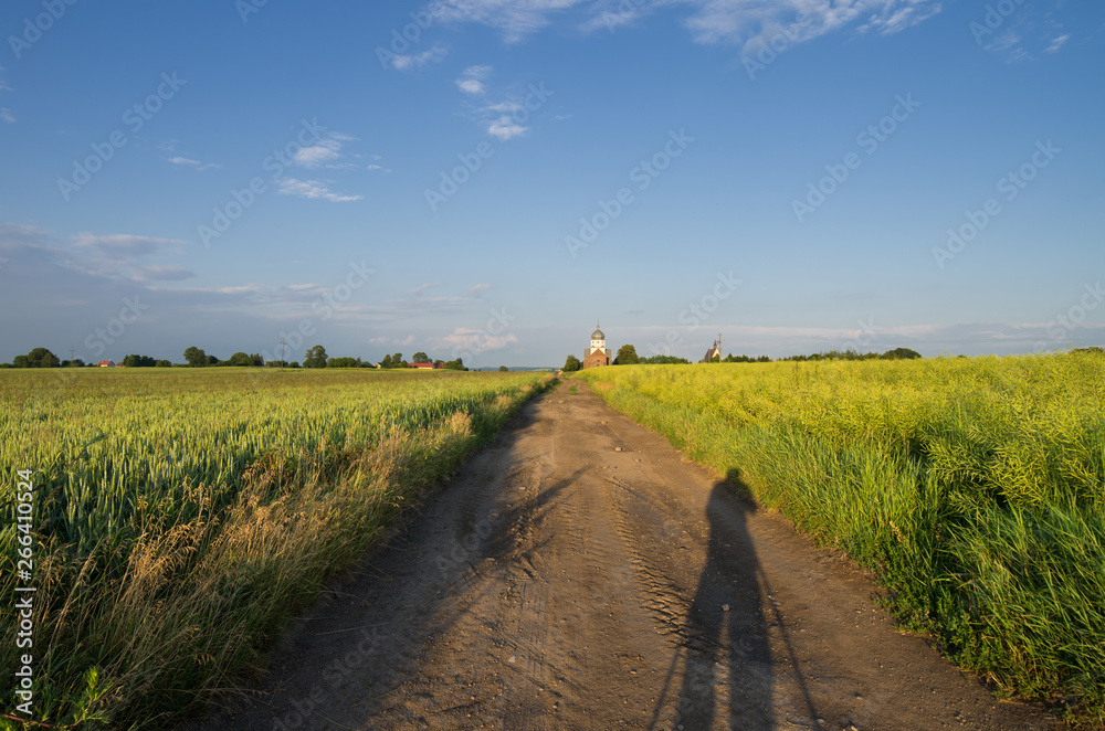 The shadow of a photographer on a dirt road