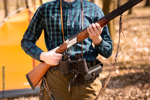 Autumn hunting season. Man hunter with a gun. Hunting in the woods