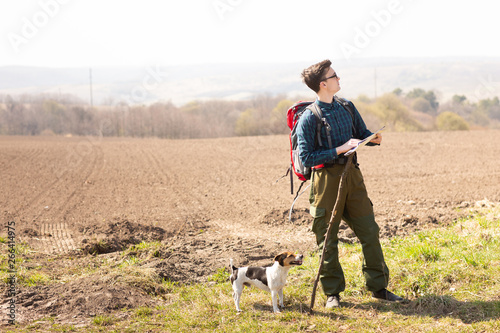 Wallpaper Mural A traveler with a backpack and his dog, looking at the map and walking in the countryside Torontodigital.ca