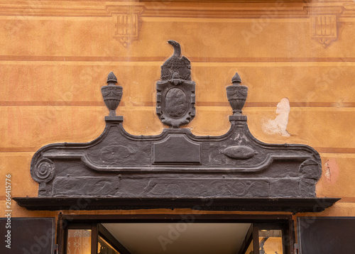Foto Close-up of an old bas-relief frieze in slate stone on the painted façade above