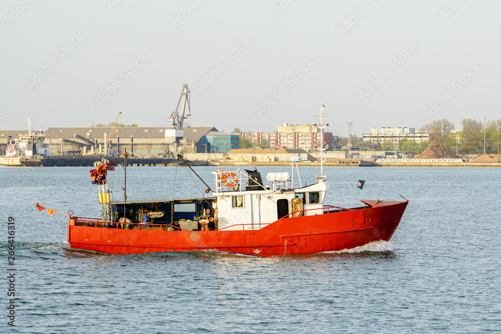 A small fishing trawler returns to the harbour A small fishing trawler returns to the harbour