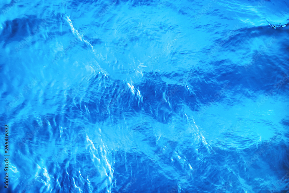 Closeup of calm sea water surface with water splashes in blue color. Ideal river, sea and ocean texture. Trendy fresh abstract nature background.