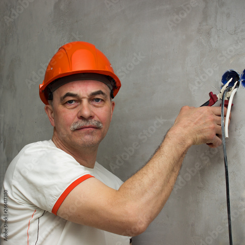 A man with a stern face cuts the wiring. Sabotage