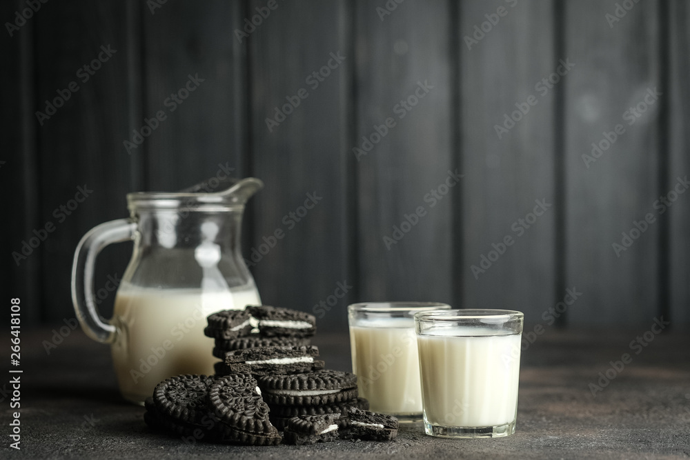 Jug of milk and chocolate chip cookies on a dark background with copy space. Jug of milk and chocolate chip cookies on a dark background with copy space.