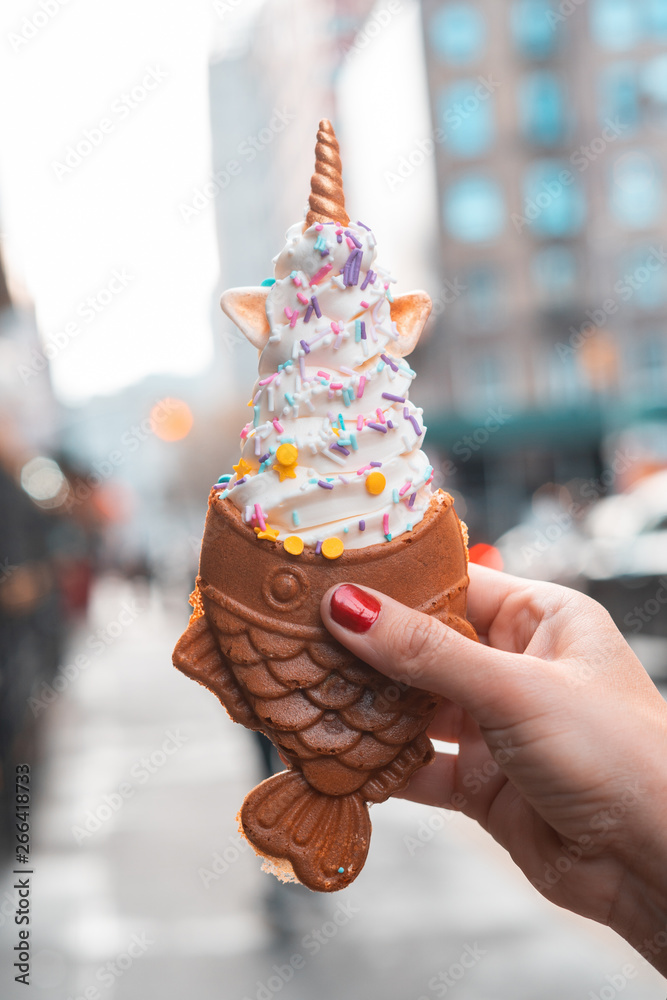 Soft Ice cream with Fish shaped waffle from Korean or Japan. Woman eating a delicious taiyaki
