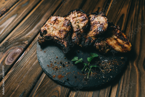 Pork bone steak on a wooden background with honey. Board slate. kenza, pepper photo