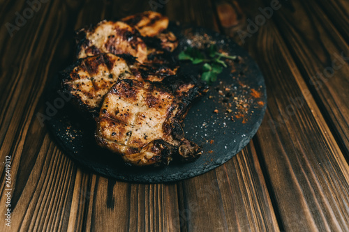 Pork bone steak on a wooden background with honey. Board slate. kenza, pepper photo