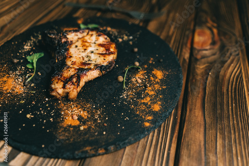 Pork bone steak on a wooden background with honey. Board slate. kenza, pepper photo