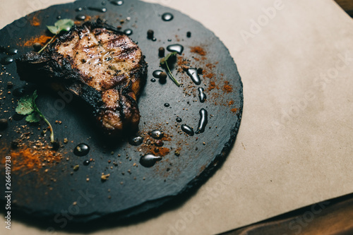 Pork bone steak on a wooden background with honey. Board slate. kenza, pepper photo