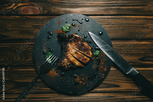 Pork bone steak on a wooden background with honey. Board slate. kenza, pepper photo