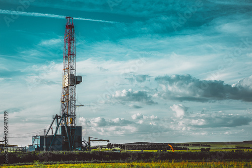 Land oil drilling rig in a green field photo
