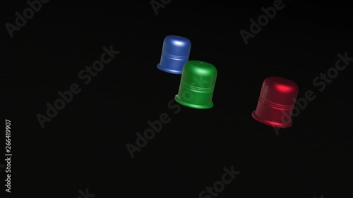 Three color thimbles on black backgrounds - metaphor.