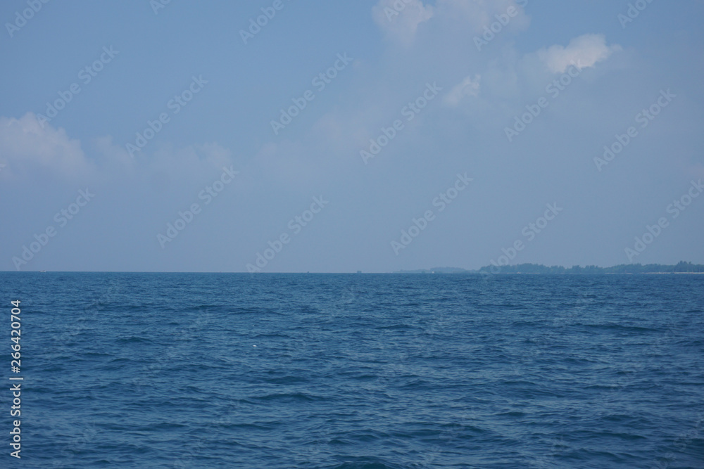 Beautiful expanse of turquoise tropical sea and white puffy clouds complete picture of tropical paradise