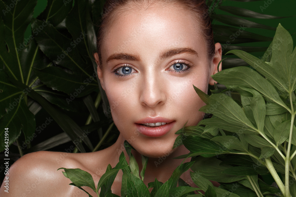 Beautiful fresh girl with perfect skin, natural make-up and green leaves. Beauty face. Beautiful fresh girl with perfect skin, natural make-up and green leaves. Beauty face.