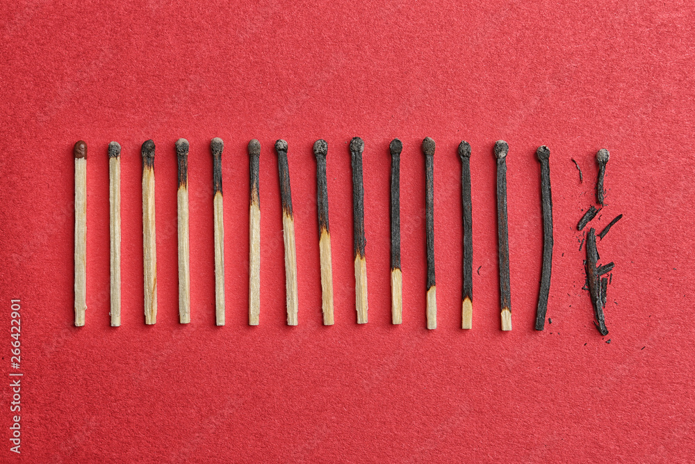 Row of burnt matches and whole one on color background, flat lay. Human life phases concept Row of burnt matches and whole one on color background, flat lay. Human life phases concept