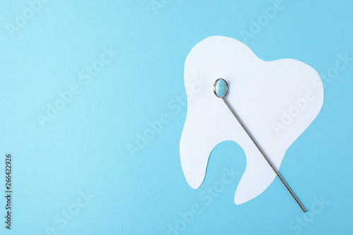 Paper tooth and dentist mirror on color background  top view with space for text