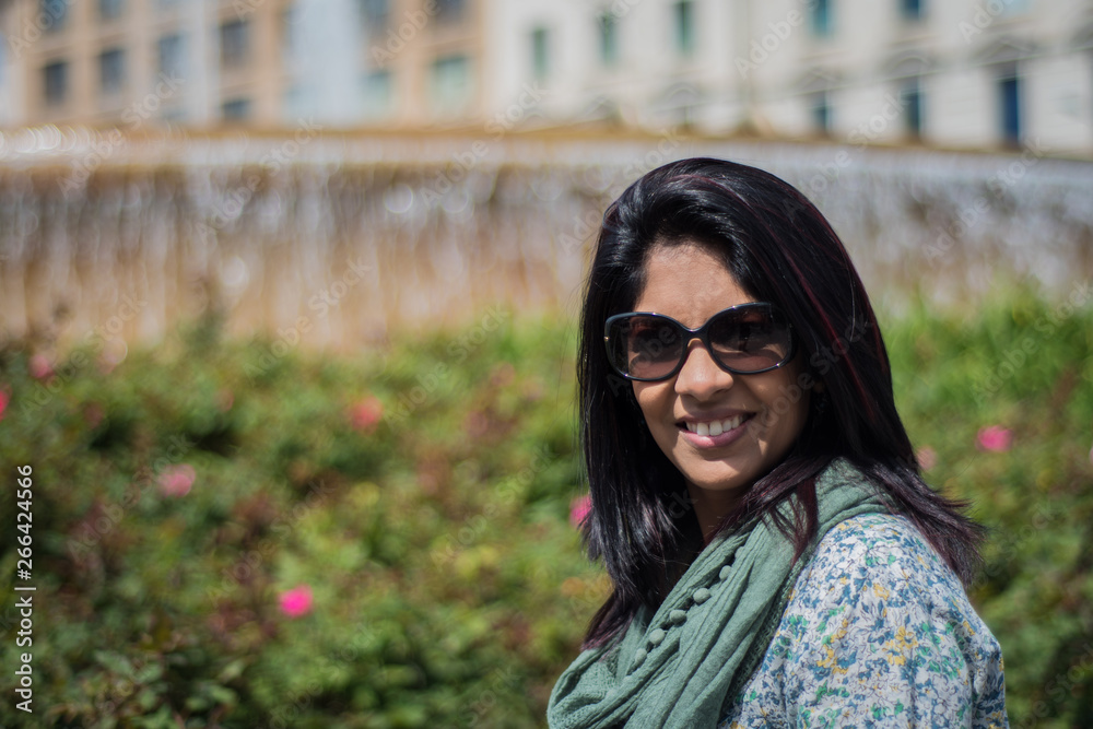 Woman of Indian ethnicity posing in sunglasses in daylight. Woman of Indian ethnicity posing in sunglasses in daylight.