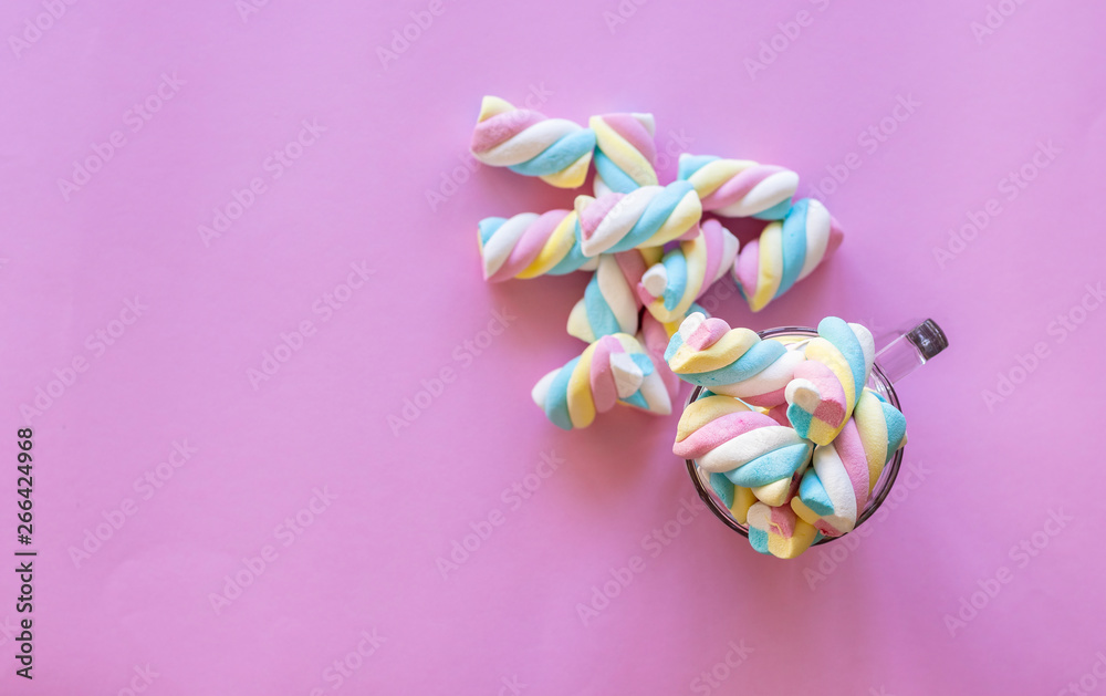cup with colorful marshmallows, pink background