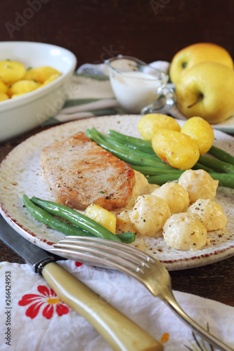 French cuisine: fried pork with Norman apple sauce, green beans and fried potatoes
