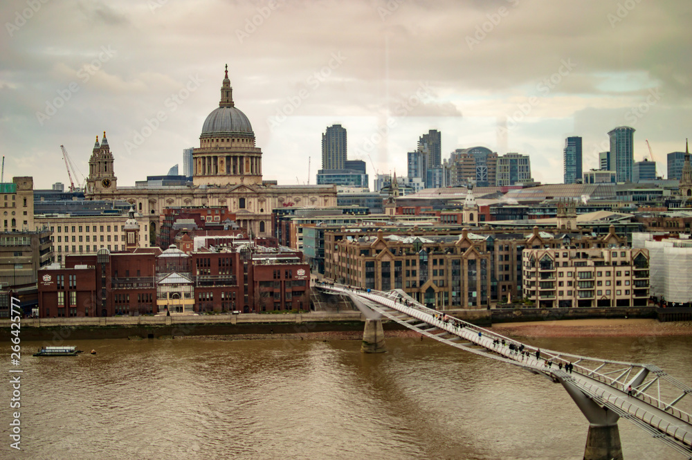 The millennium bridge in london uk on thames river and buildings across