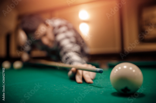Russian billiards, man plays and beats cue on white ball